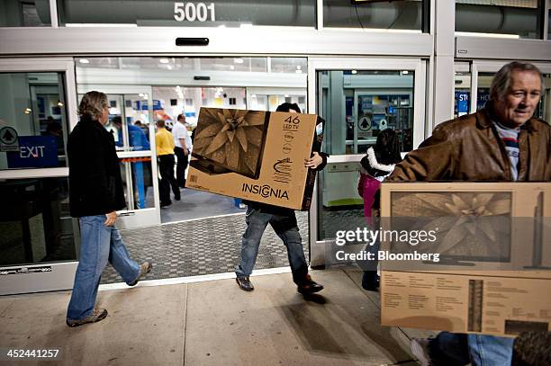 Customers exit a Best Buy Co. Store carrying newly purchased Insignia-brand televisions ahead of Black Friday in Peoria, Illinois, U.S., on Thursday,...