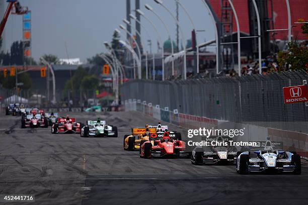 Helio Castroneves of Brazil driver of the Team Penske Dallara Chevrolet leads a pack of cars at the start of the Verizon IndyCar Series Honda Indy...