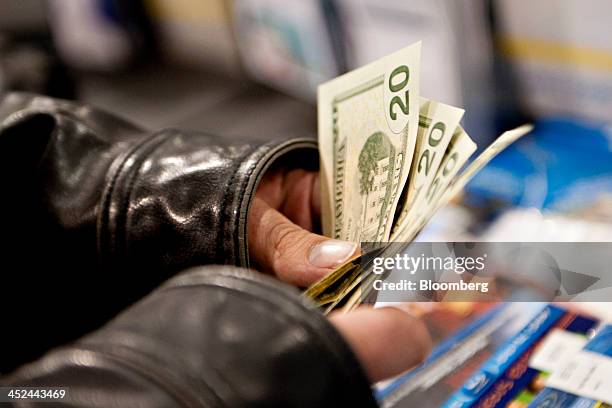 Customer counts his money as he prepares to pay for merchandise at a Best Buy Co. Store ahead of Black Friday in Peoria, Illinois, U.S., on Thursday,...