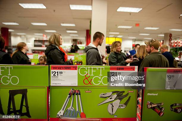 Shoppers wait in line to pay for merchandise at a Sears Holdings Corp. Store ahead of Black Friday in Peoria, Illinois, U.S., on Thursday, Nov. 28,...