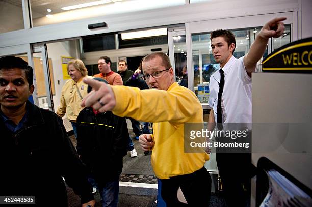 Employees direct customers to merchandise at a Best Buy Co. Store ahead of Black Friday in Peoria, Illinois, U.S., on Thursday, Nov. 28, 2013. U.S....