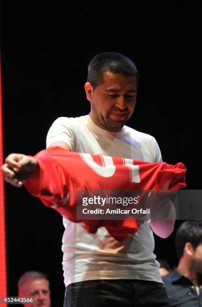 Juan Roman Riquelme tries on his jersey during a press conference after his official unveiling as a new Argentinos Jrs player at Panamericano Hotel...