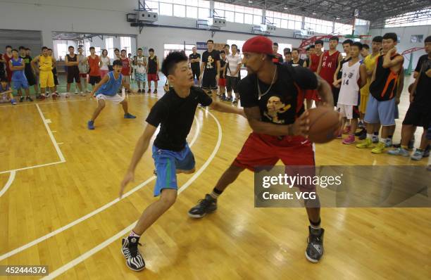 Player George Hill coaches students at George Hill China Basketball Training Center on July 20, 2014 in Zhengzhou, Henan province of China.