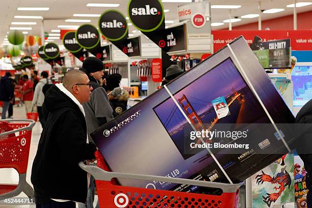 Customer picks up a shopping cart containing an Element Electronics 50-inch light-emitting diode high definition television at a Target Corp. Store...