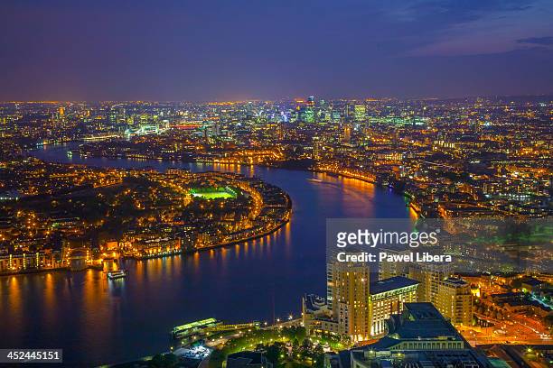Aerial view on London skyline and River Thames at night from top of One Canada Square Tower aka Canary Wharf.