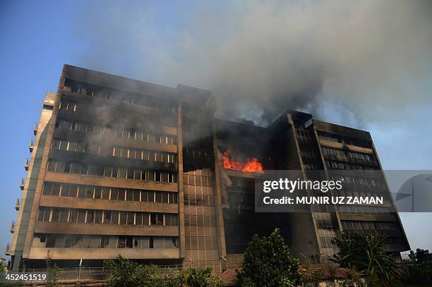 Smoke and flames billow from a burning garment factory in the key Bangladesh garment manufacturing hub of Gazipur on the outskirts of Dhaka on...