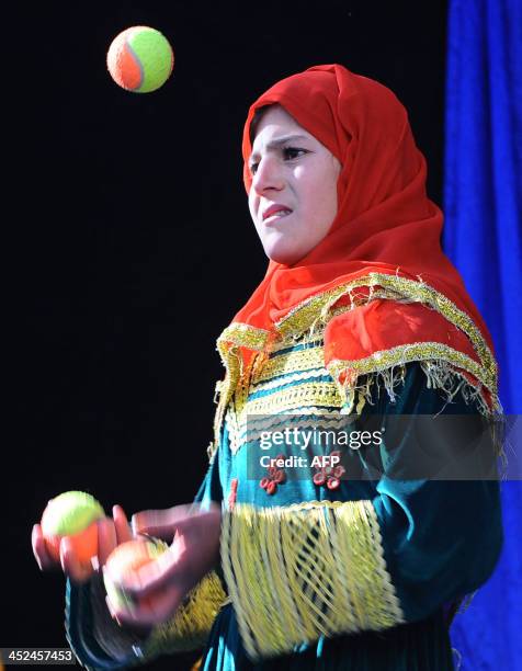 An Afghan child from The Mobile Mini Circus for Children juggles during a circus show in Kabul on November 29, 2013. The Mobile Mini Circus for...