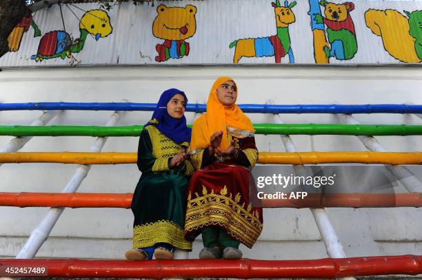 Afghan children look on as performers from The Mobile Mini Circus for Children take part in a circus show in Kabul on November 29, 2013. The Mobile...