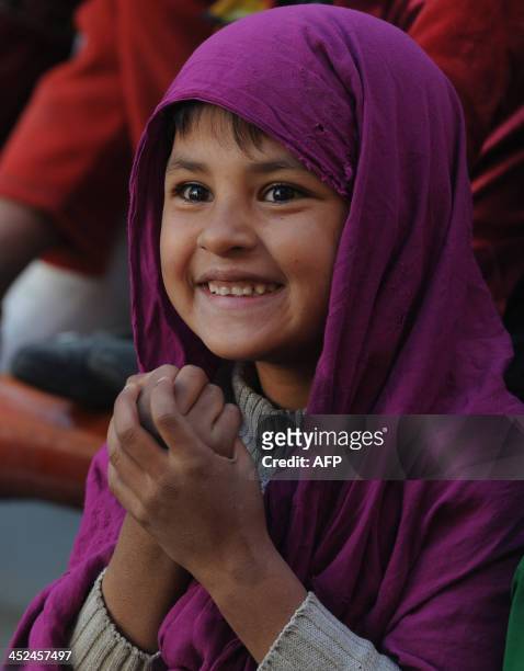 An Afghan child looks on as performers from The Mobile Mini Circus for Children take part in a circus show in Kabul on November 29, 2013. The Mobile...