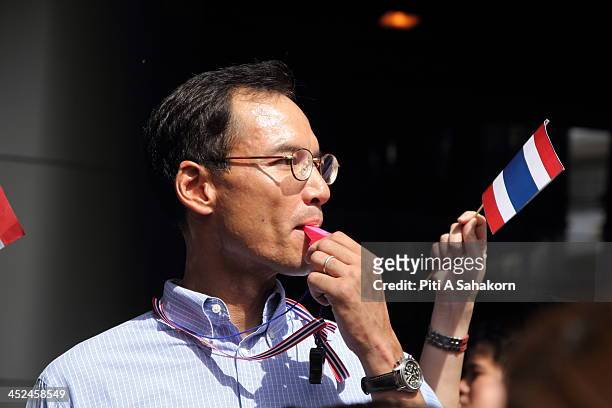 Democrat Party member and former Thai finance minister Korn Chatikavanij blows a whistle during a march from Asoke intersection to the US embassy in...