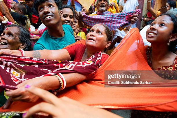 Devotees jostle to get holy rice that is thrown from the top of a temple during Annakut festival. People in large numbers gather at a temple in...