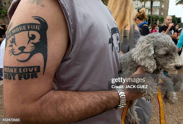 An Israeli, having a anti-fur tatoo on his arm, attend a fake fashion by anti-fur activists during the Worldwide Fur Free Friday initiated by the...