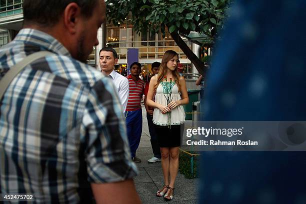 An Ukranian woman holds two flowers during a candle light vigil for the victims of MH17 on July 21, 2014 in Kuala Lumpur, Malaysia. Malaysian...