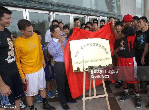 Player George Hill unveils the nameplate for the George Hill China Basketball Training Center on July 20, 2014 in Zhengzhou, Henan province of China.