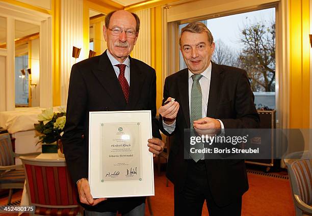 President Wolfgang Niersbach presents Herbert Roesch, president of the Baden-Wuertemberg football association with the Silberne Ehrennadel prior to...