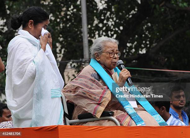 Party chief and West Bengal Chief Minister Mamata Banerjee gets emotional as noted writer Mahasweta Devi speaks during Shaheed Diwas rally organized...