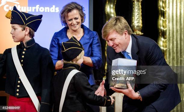 Dutch King Willem-Alexander and director of the Prins Bernhard Cultuurfonds foundation Adriana Esmeijer receive the biographies of the first three...