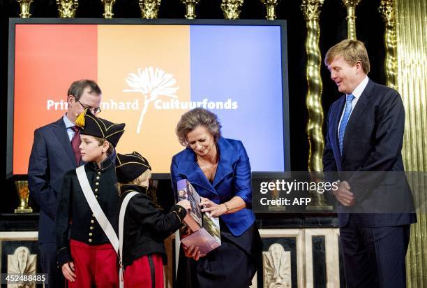 Dutch King Willem-Alexander and director of the Prins Bernhard Cultuurfonds foundation Adriana Esmeijer receive the biographies of the first three...