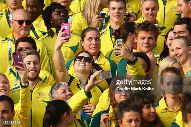 Members of the Australian team take selfies as they wait for the Australian team photo before the Australian Commonwealth Games official team...