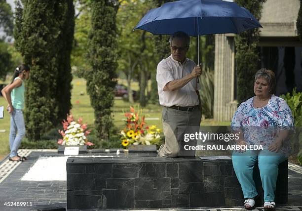 The sister of the Colombian drug lord Pablo Escobar, Luz Maria Escobar and her housband Leonardo Arteaga, stand next to Escobar's tomb on November...