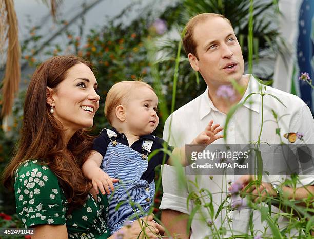 Catherine, Duchess of Cambridge holds Prince George as he and Prince William, Duke of Cambridge's look on while visiting the Sensational Butterflies...