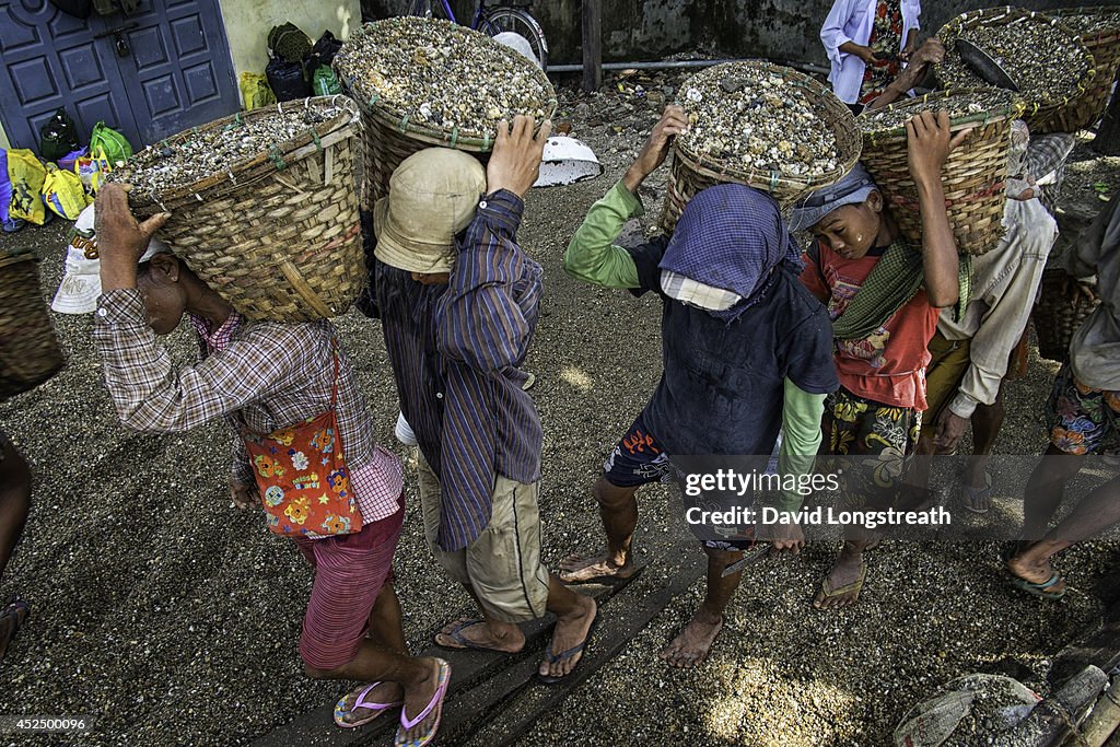 Myanmar day laborers carry 40 plus kilogram baskets of river...