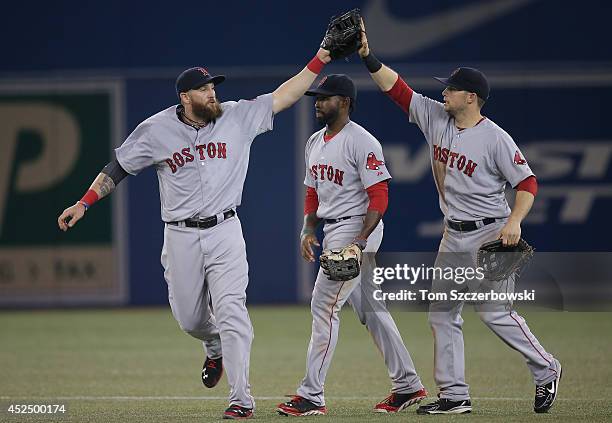 Jonny Gomes of the Boston Red Sox celebrates their victory with Jackie Bradley Jr. #25 and Daniel Nava during MLB game action against the Toronto...