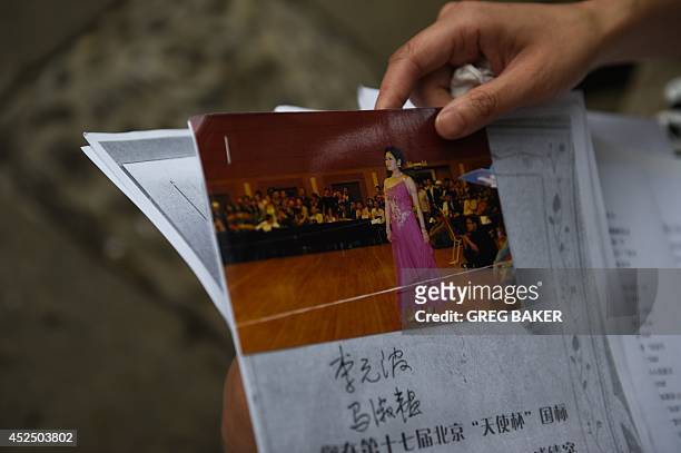 China-social-women-crime,FEATURE by Felicia Sonmez This photo taken on July 17, 2014 shows Ma Shuyun holding a photo of herself at an amateur...