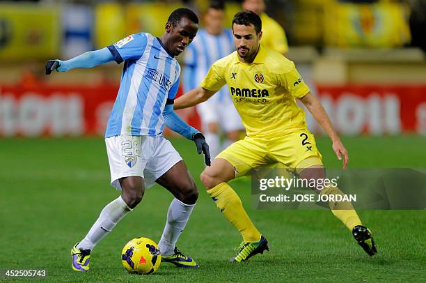 Malaga's Cameroonian forward Fabrice Olinga vies with Villarreal's defender Mario during the Spanish league football match Villareal CF vs Malaga at...