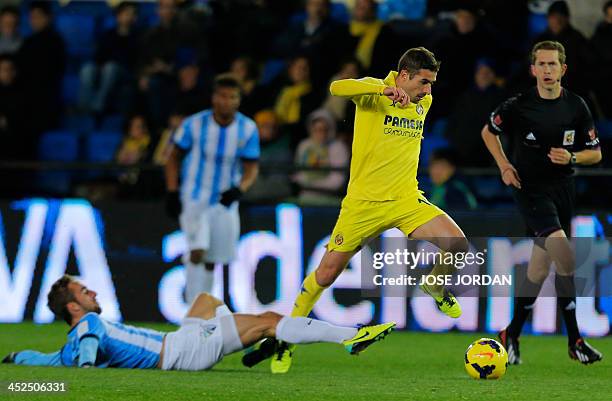 Malaga's midfielder Sergi Darder vies with Villarreal's midfielder Cani during the Spanish league football match Villareal CF vs Malaga at El...