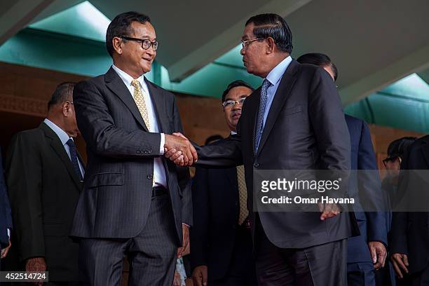 Cambodian Prime Minister Hun Sen shakes hands with the President of the opposition Cambodia National Rescue Party, Sam Rainsy after a meeting during...