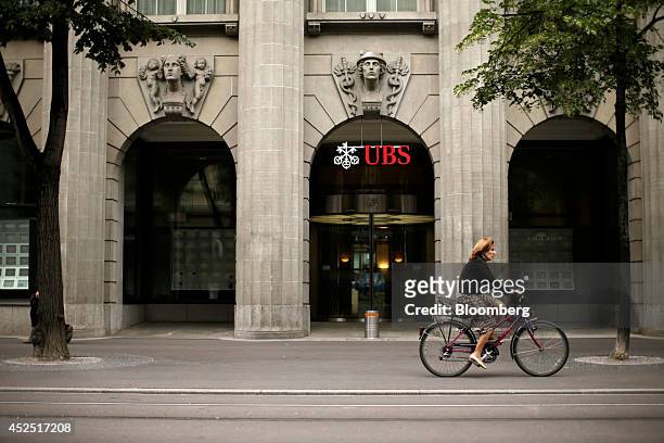 Cyclist passes the headquarters of UBS AG in Zurich, Switzerland, on Monday, July 21, 2014. Zurich-based Credit Suisse Group AG posted...