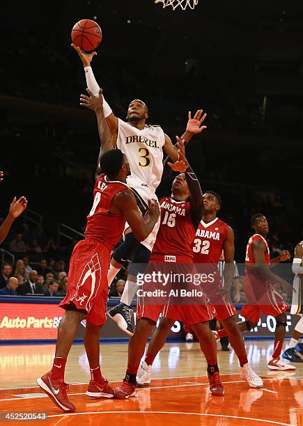Chris Fouch of the Drexel Dragons shoots against Algie Key of Alabama Crimson Tide and Nick Jacobs of during their consolation game of the NIT Season...