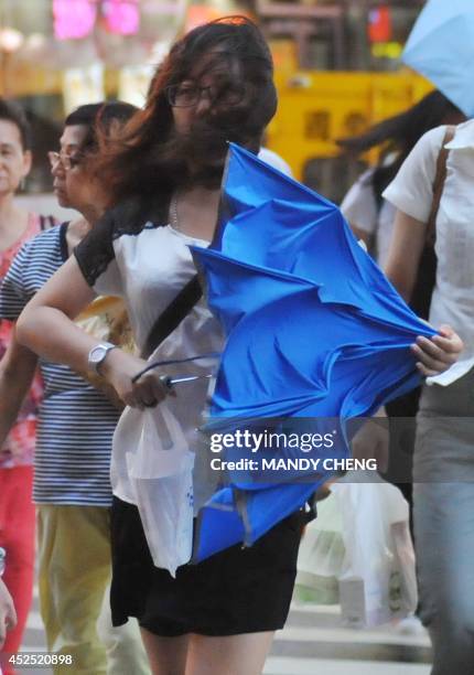 Pedestrian battles against strong winds in Taipei on July 22, 2014 as Typhoon Matmo approaches eastern Taiwan. Typhoon Matmo churned towards Taiwan...