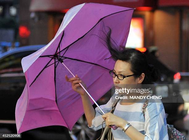 Pedestrian battles against strong winds in Taipei on July 22, 2014 as Typhoon Matmo approaches eastern Taiwan. Typhoon Matmo churned towards Taiwan...