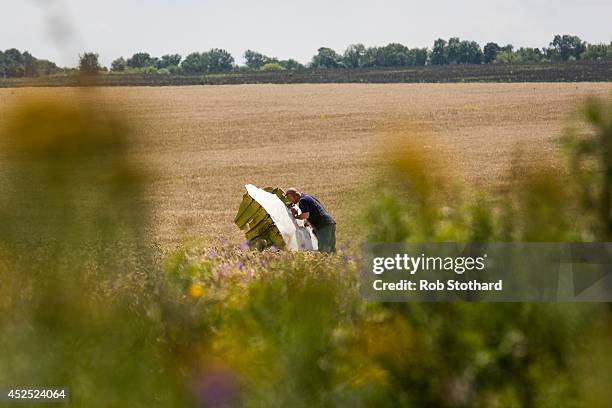 Malaysian official inspects wreckage of Malaysia Airlines flight MH17 during monitoring by investigators from Malaysia and the Organization for...