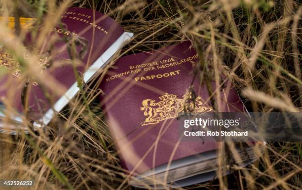 Two Dutch passports lie in a field amongst luggage, personal belongings and wreckage from Malaysia Airlines flight MH17 on July 22, 2014 in Grabovo,...