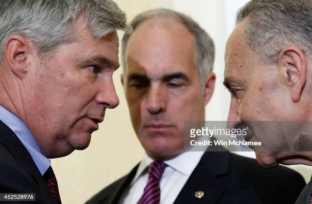 Sen. Sheldon Whitehouse confers with U.S. Sen. Charles Schumer as U.S. Sen. Robert Casey listens during a press conference about the "Bring Jobs Home...