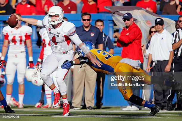 Quarterback Derek Carr of the Fresno State Bulldogs wiggles free of a tackle by linebacker Keith Smith of the San Jose State Spartans on a back and...