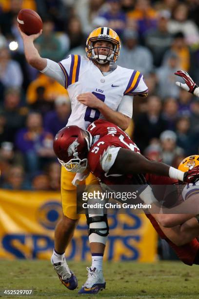 Quarterback Zach Mettenberger of the LSU Tigers throws a pass as he is hit by Byran Jones of the Arkansas Razorbacks at Tiger Stadium on November 29,...
