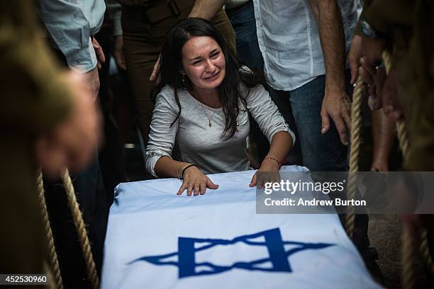 Woman mourns over the casket of Israeli soldier Jordan Bensimon during his funeral on July 22, 2014 in Ashkelon, Israel. Bensimon was 22 and...