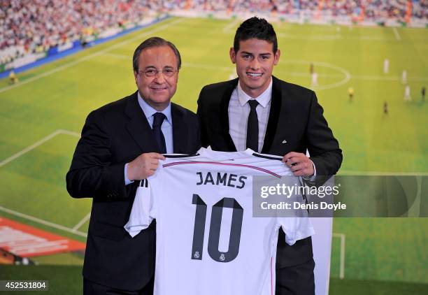 James Rodriguez holds his new Real shirt beside club president Florentino Perez during his unveiling as a new Real Madrid player at the Santaigo...