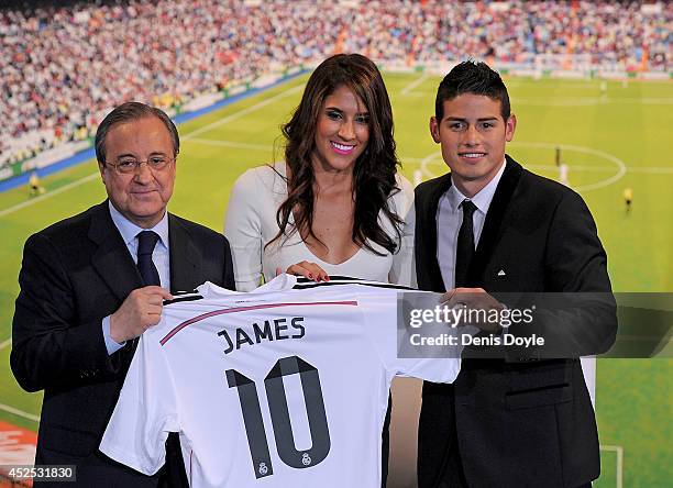 James Rodriguez holds his new Real shirt beside club president Florentino Perez and his wife Daniela Ospina during his unveiling as a new Real Madrid...