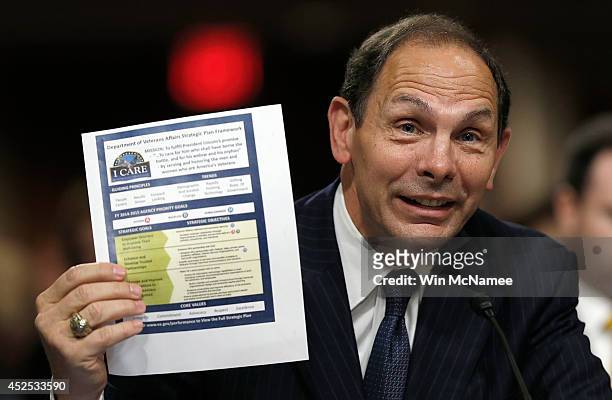 Robert McDonald, President Obama's nominee to be the Secretary of Veterans Affairs, holds up a copy of the Veterans Affairs 'Strategic Plan...