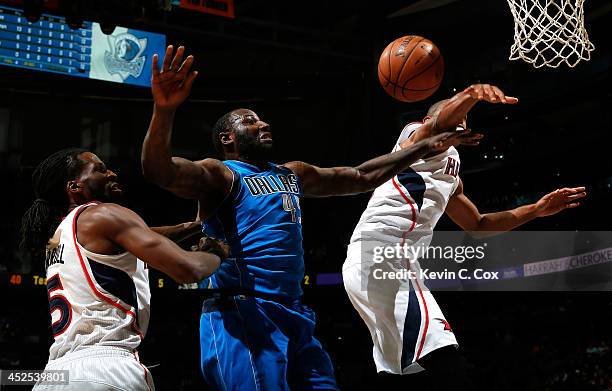 DeJuan Blair of the Dallas Mavericks battles for a rebound against DeMarre Carroll and Al Horford of the Atlanta Hawks at Philips Arena on November...