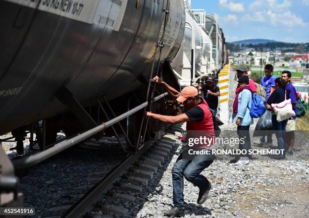 Central American migrants get on the so-called La Bestia cargo train, in an attempt to reach the US border, in Apizaco, Tlaxcala state, Mexico on...