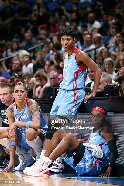 Erika de Souza, Angel McCoughtry, and Aneika Henry of the Atlanta Dream wait to enter the game against the Minnesota Lynx during the WNBA game on...