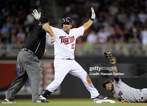 Kendrys Morales of the Minnesota Twins reacts as umpire Brian O'Nora calls him out at second base and Jason Kipnis of the Cleveland Indians shows the...