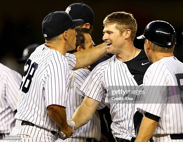 Chase Headley of the New York Yankees is congratulated by manager Joe Girardi after Headley drove in the game winning run against the Texas Rangers...