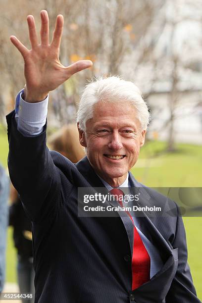 Former U.S. President Bill Clinton waves as he leaves the 20th International AIDS Conference at The Melbourne Convention and Exhibition Centre on...